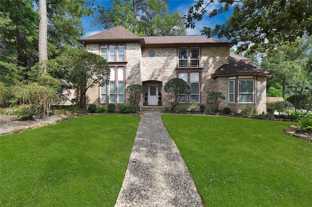 view of front of house featuring a front lawn and brick siding