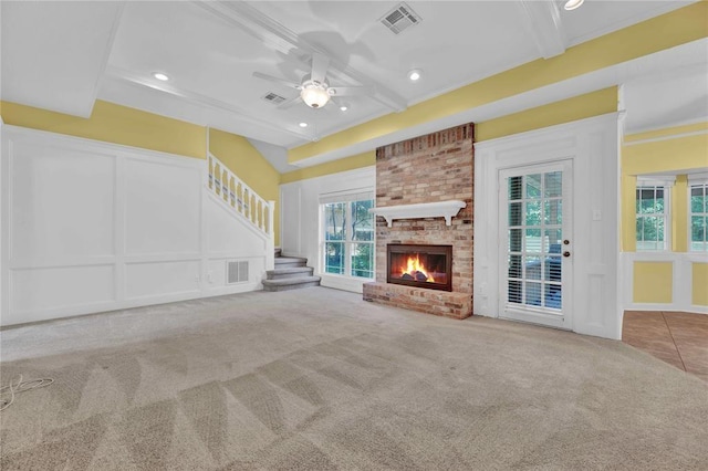 unfurnished living room with carpet floors, a brick fireplace, visible vents, and a decorative wall