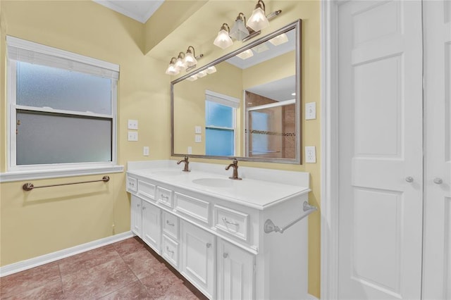 full bath featuring baseboards, crown molding, a sink, and double vanity