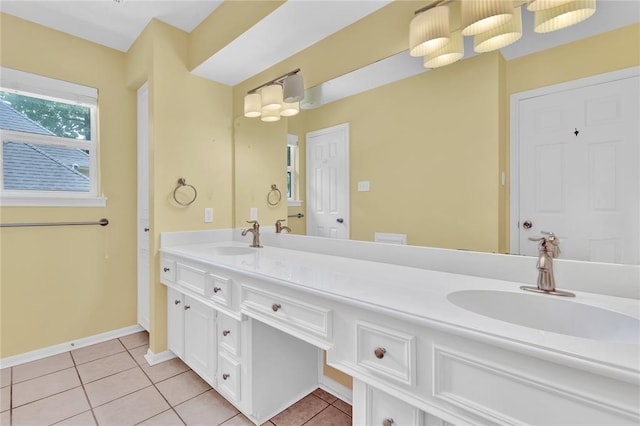 bathroom with double vanity, baseboards, a sink, and tile patterned floors