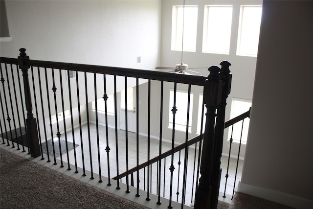 stairway featuring ceiling fan