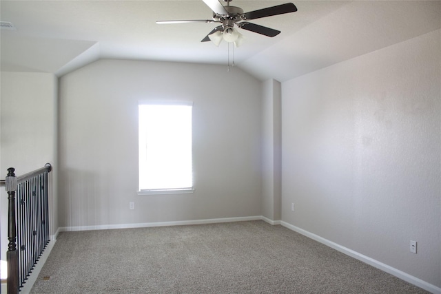 empty room featuring ceiling fan, lofted ceiling, and carpet