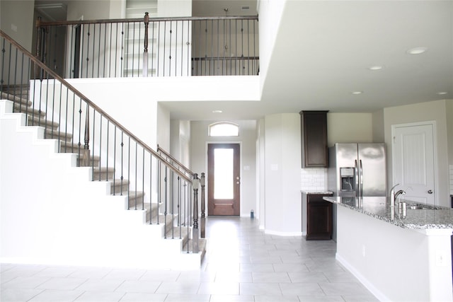 entrance foyer featuring a towering ceiling and sink