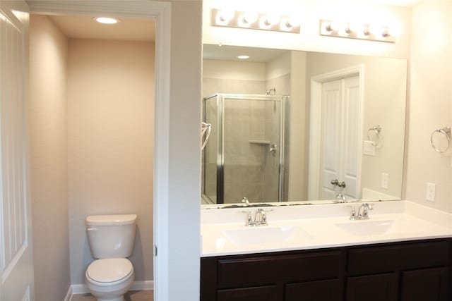 bathroom featuring vanity, toilet, and a shower with door