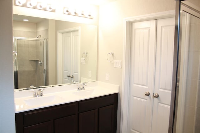 bathroom with vanity and a shower with door