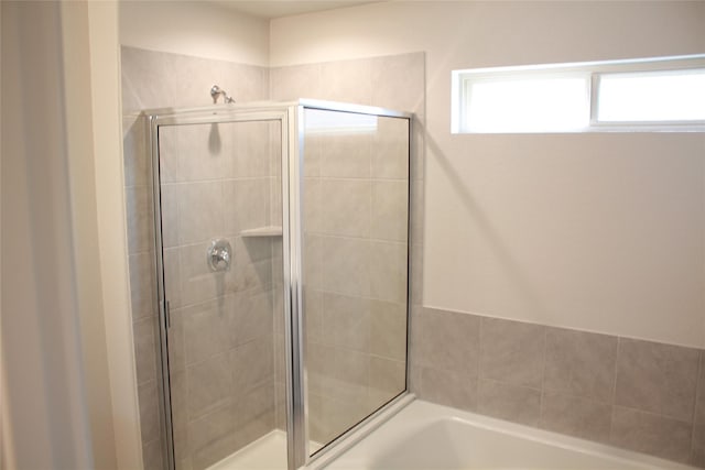 bathroom featuring independent shower and bath