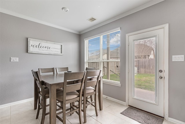 dining space featuring ornamental molding and light tile patterned floors