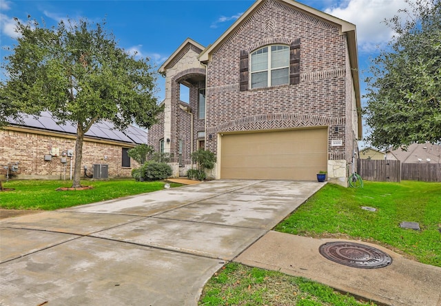 view of front of property featuring central AC, a garage, a front lawn, and solar panels