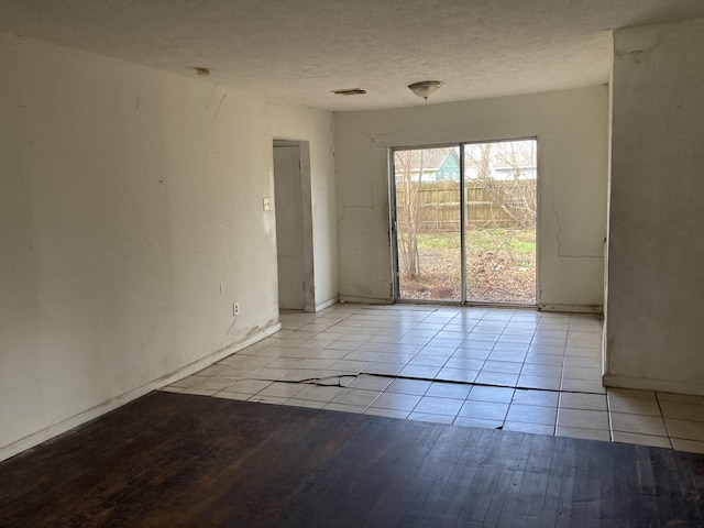 unfurnished room featuring light wood-type flooring and a textured ceiling