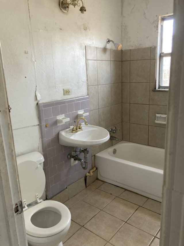 full bathroom with sink, tile walls, tile patterned flooring, toilet, and tiled shower / bath