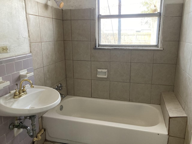 bathroom featuring sink and tile walls