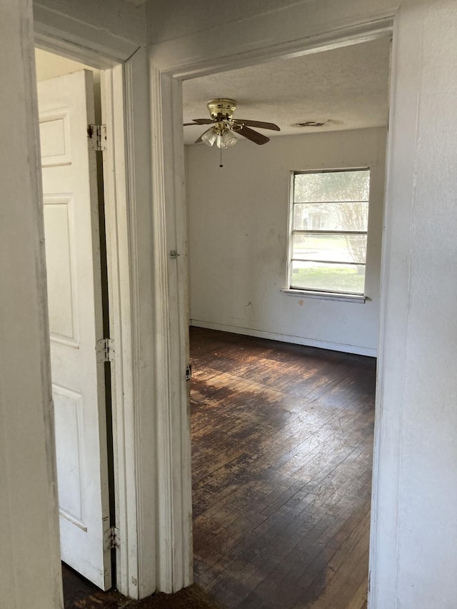 unfurnished room with dark hardwood / wood-style flooring and ceiling fan