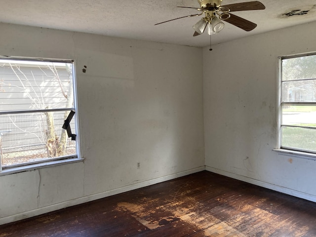 spare room with dark hardwood / wood-style flooring, a textured ceiling, and ceiling fan