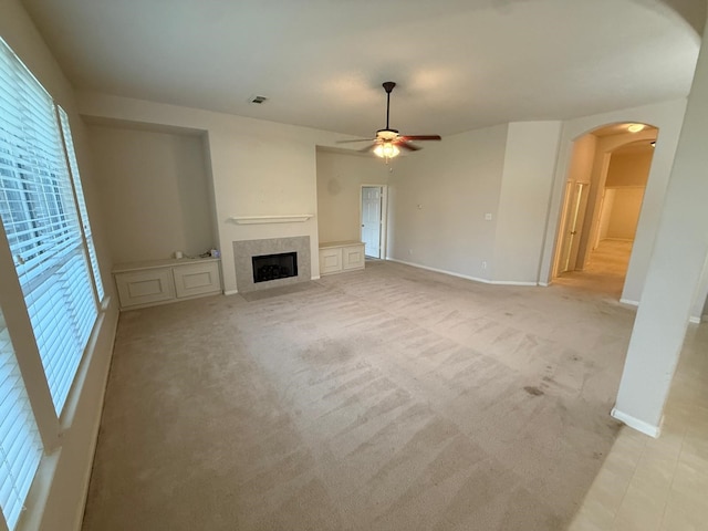 unfurnished living room featuring ceiling fan and light carpet