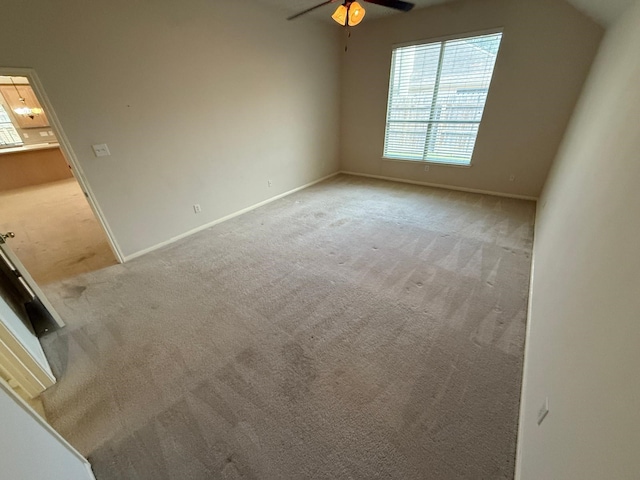 unfurnished room with light colored carpet and ceiling fan