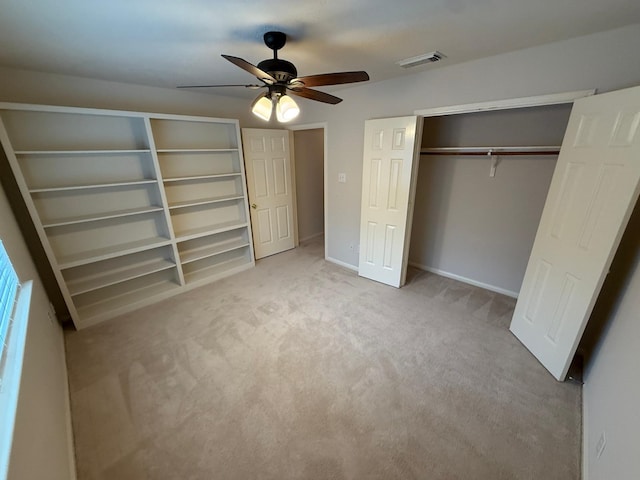 unfurnished bedroom featuring light colored carpet, ceiling fan, and a closet