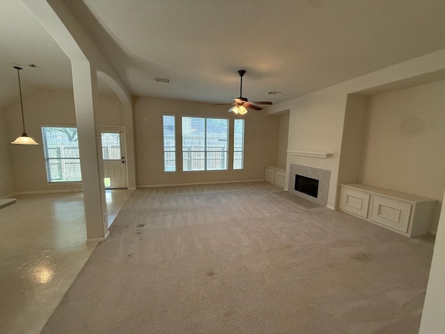 unfurnished living room featuring light carpet, a wealth of natural light, and ceiling fan