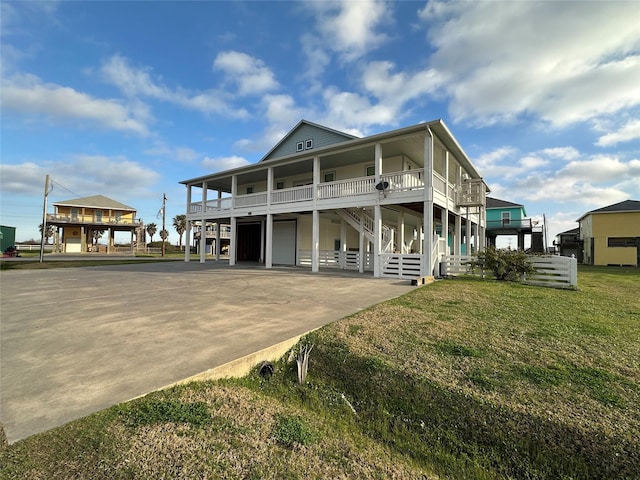 beach home featuring a garage, a porch, and a front yard