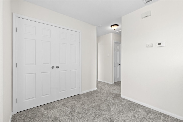 unfurnished bedroom with light carpet and a closet