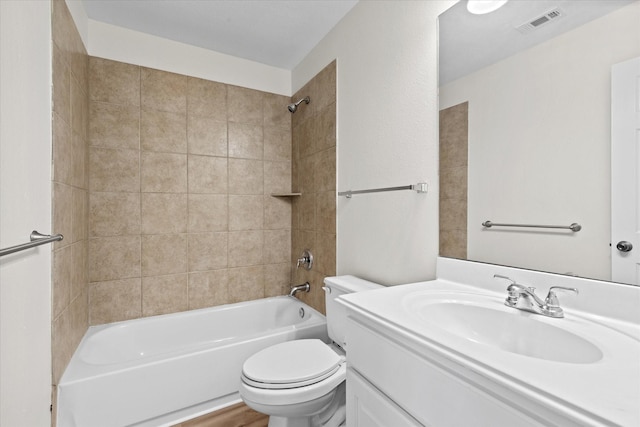 full bathroom featuring tiled shower / bath combo, vanity, and toilet