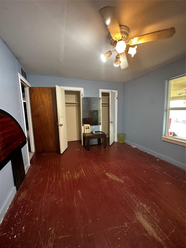 unfurnished bedroom featuring dark wood-type flooring and ceiling fan