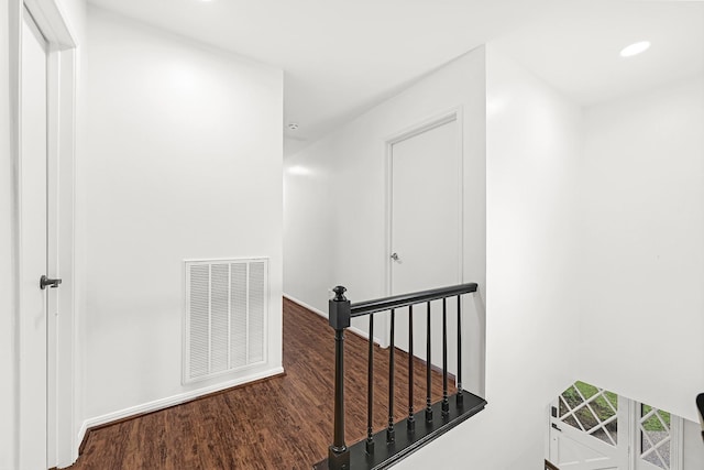 corridor with recessed lighting, visible vents, wood finished floors, and an upstairs landing