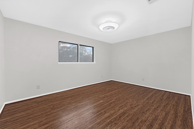 unfurnished room featuring dark wood-style floors and baseboards