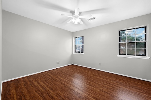 unfurnished room with visible vents, ceiling fan, baseboards, and wood finished floors