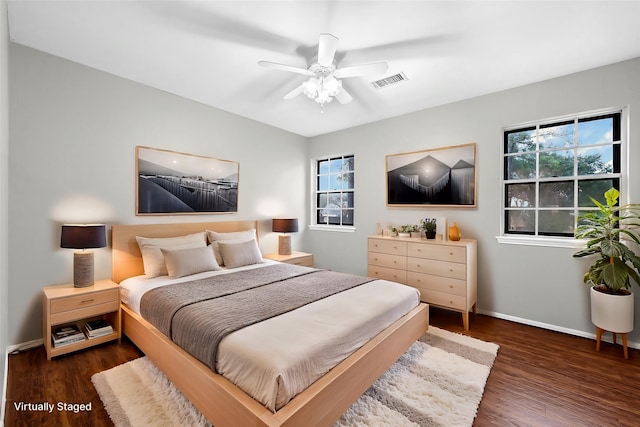 bedroom featuring a ceiling fan, visible vents, baseboards, and wood finished floors