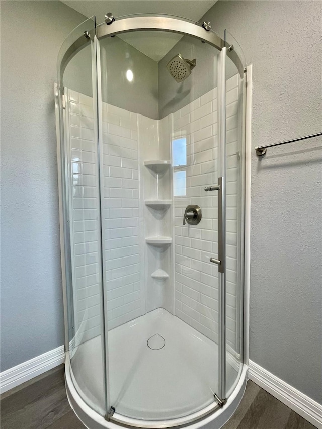 bathroom with hardwood / wood-style flooring and a shower with door