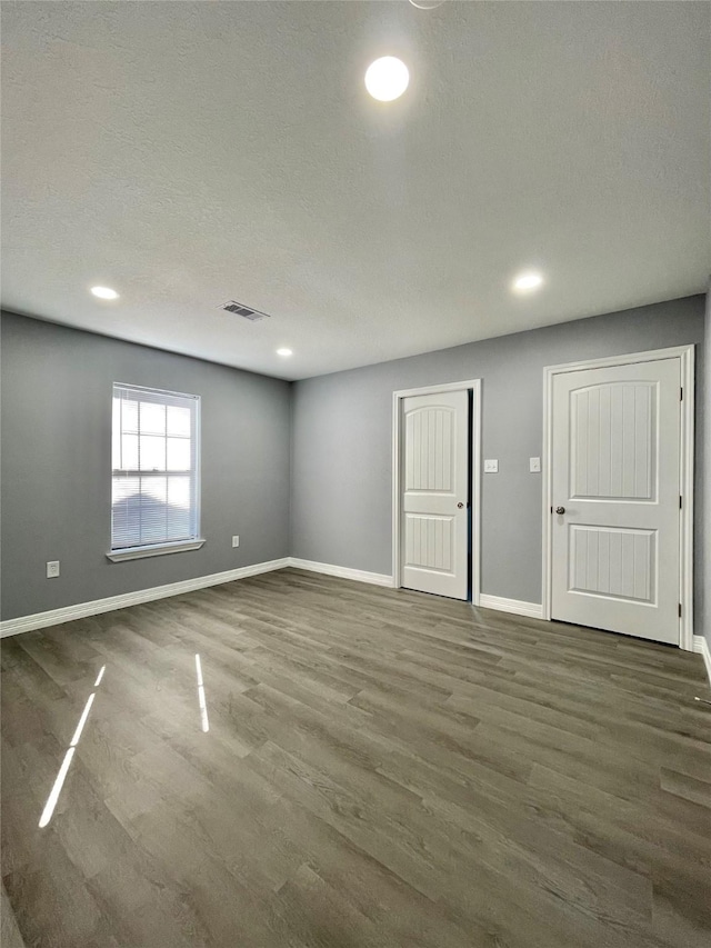 empty room featuring dark hardwood / wood-style floors and a textured ceiling