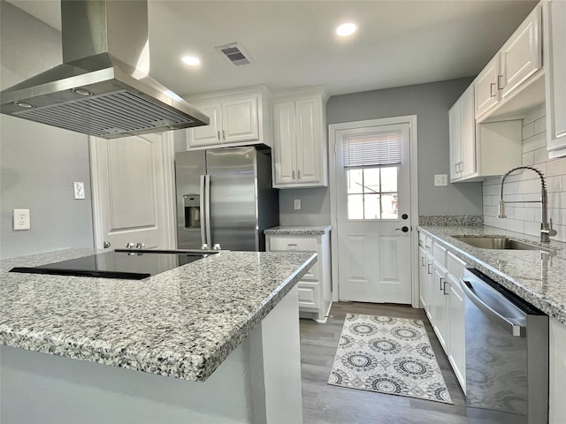 kitchen with sink, white cabinetry, stainless steel appliances, light stone countertops, and island exhaust hood