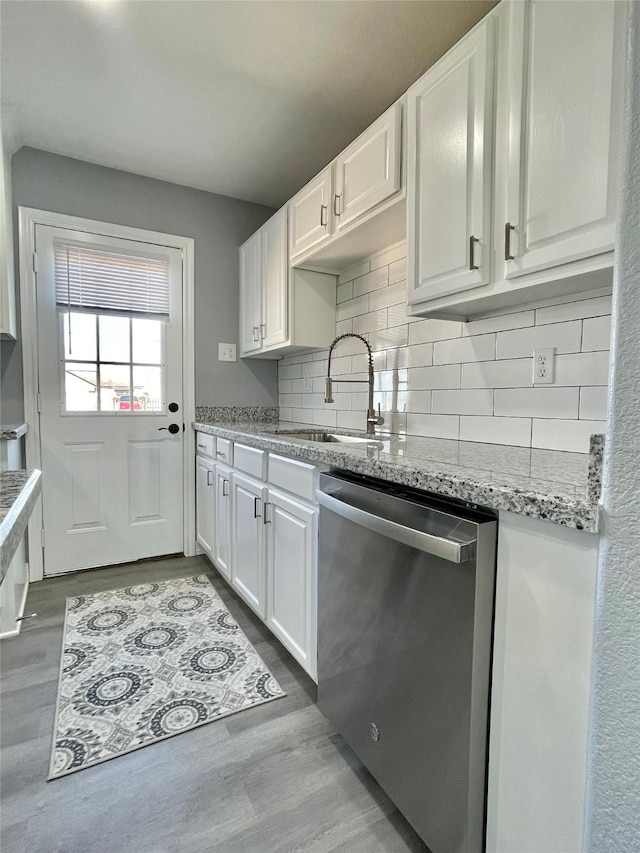 kitchen featuring white cabinetry, light hardwood / wood-style floors, dishwasher, and sink