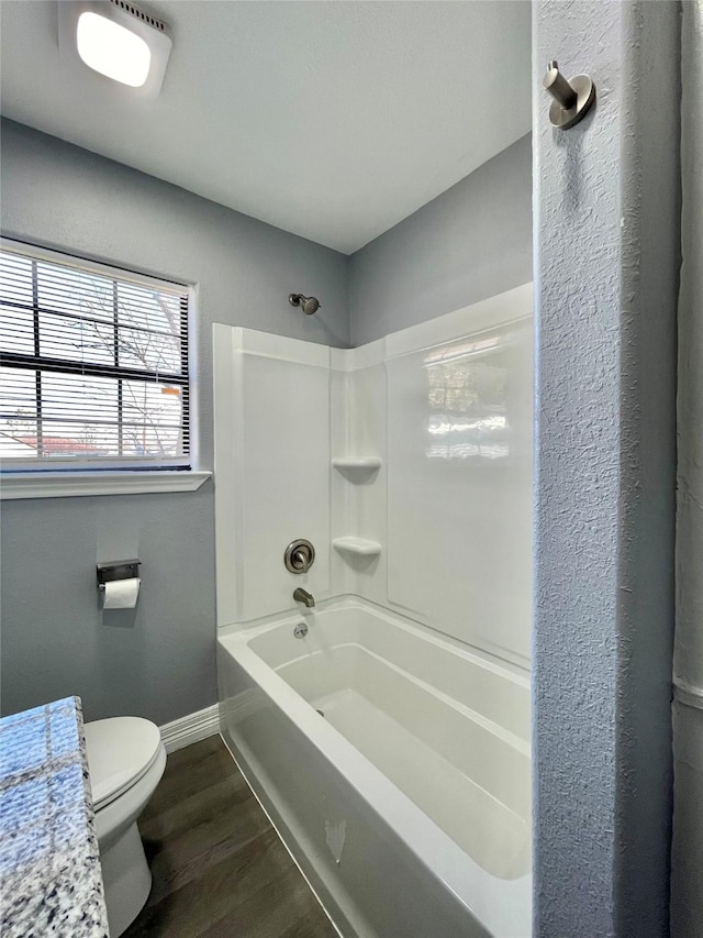 bathroom featuring hardwood / wood-style flooring, toilet, and shower / bathing tub combination