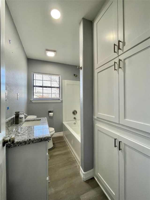 full bathroom featuring vanity, wood-type flooring, toilet, and washtub / shower combination