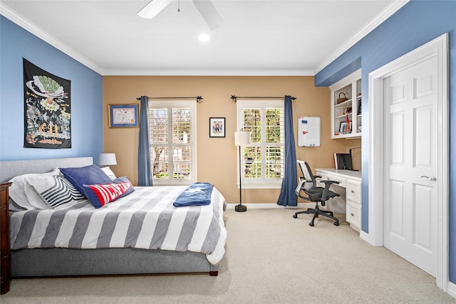 bedroom with light colored carpet, crown molding, built in desk, and baseboards