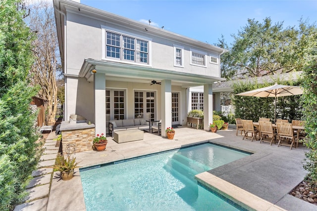 back of property featuring a patio, stucco siding, fence, ceiling fan, and an outdoor pool