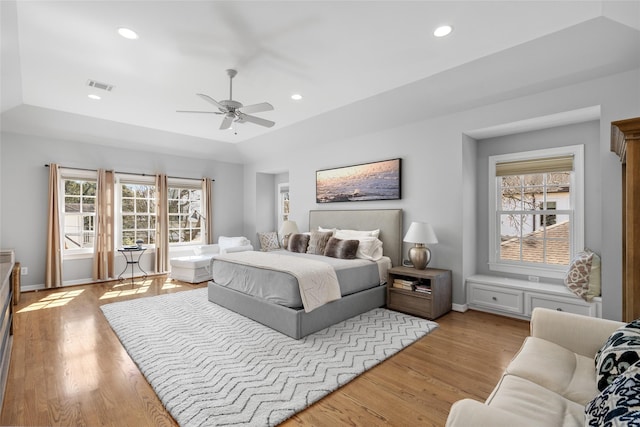 bedroom with recessed lighting, visible vents, baseboards, light wood-type flooring, and a raised ceiling