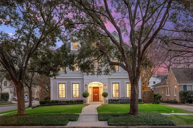 view of front of home with a front yard and stucco siding