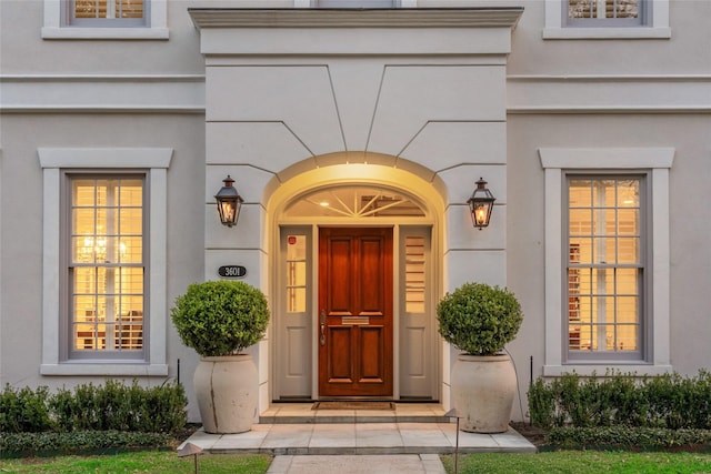 entrance to property featuring stucco siding