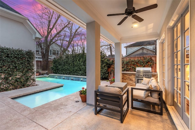 view of swimming pool with area for grilling, a patio, ceiling fan, a fenced backyard, and exterior kitchen