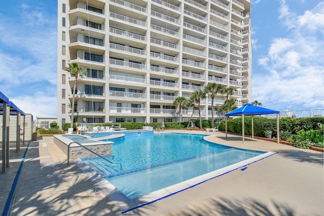 view of swimming pool with a jacuzzi and a patio