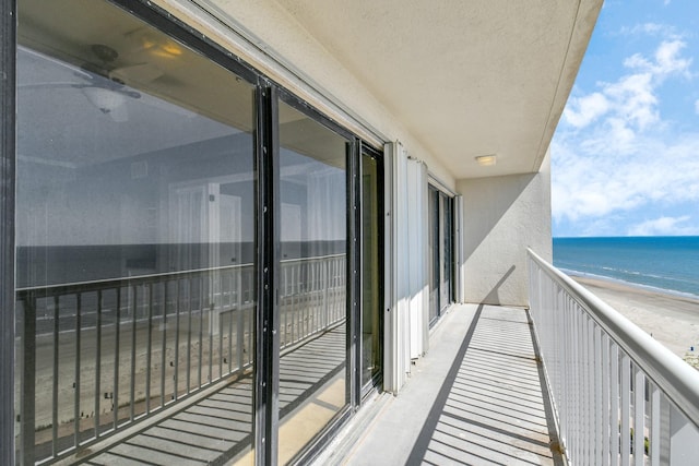 balcony featuring a beach view and a water view