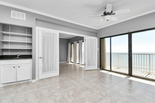 interior space featuring crown molding, a water view, sink, and ceiling fan