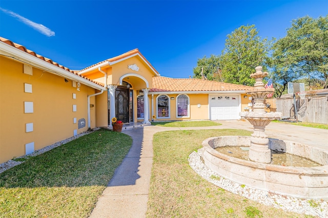 mediterranean / spanish-style home with a garage and a front yard