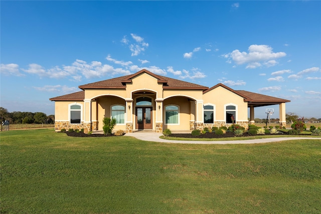 mediterranean / spanish house featuring a front lawn and french doors