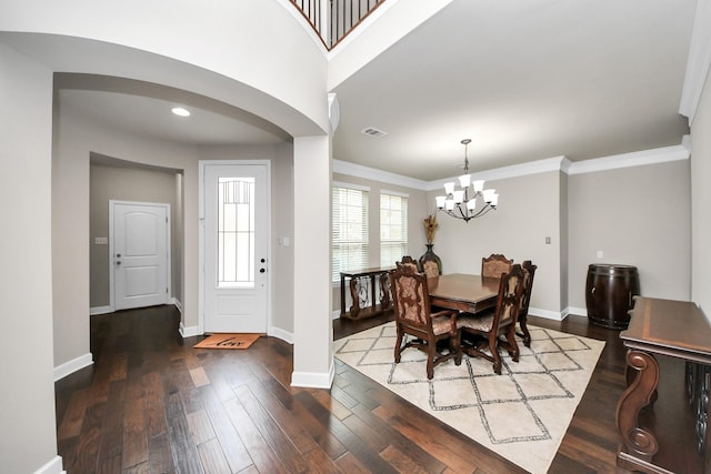 dining area featuring crown molding, an inviting chandelier, and dark hardwood / wood-style flooring