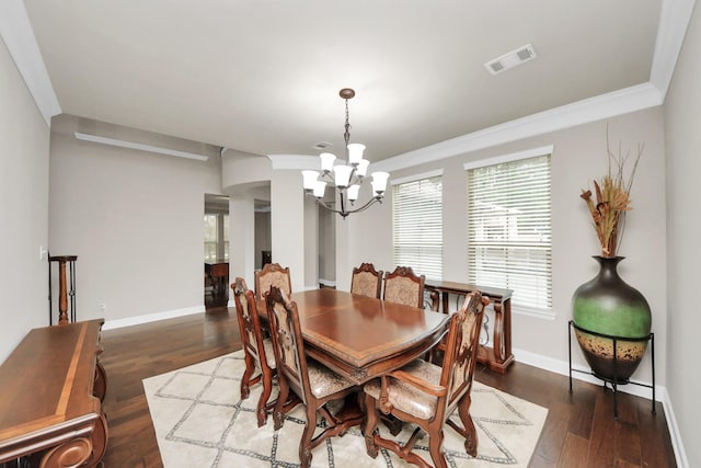 dining room featuring crown molding, dark wood-type flooring, and an inviting chandelier