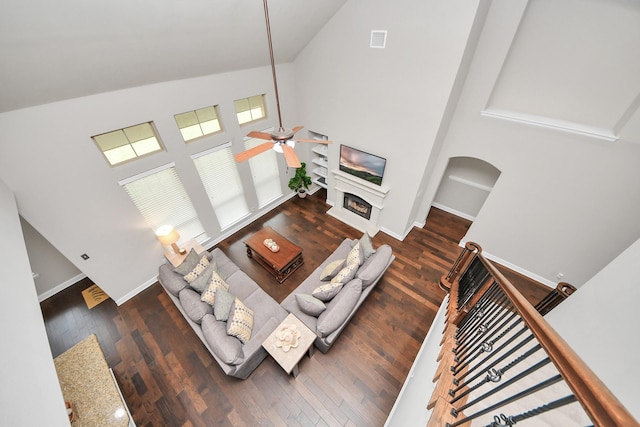 living room featuring ceiling fan, high vaulted ceiling, and dark hardwood / wood-style flooring