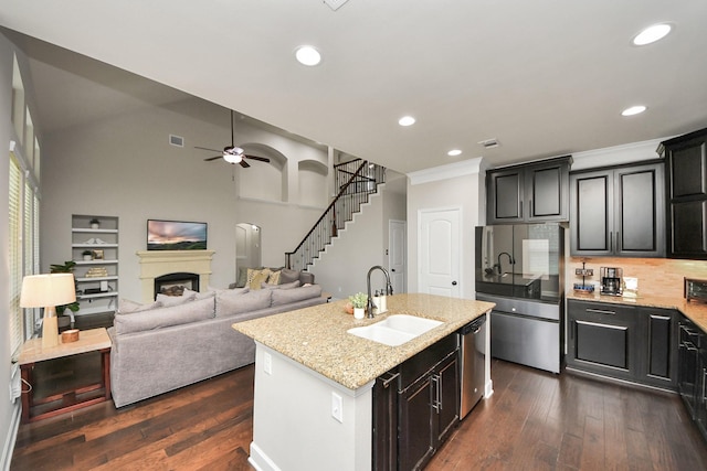 kitchen featuring an island with sink, appliances with stainless steel finishes, sink, and dark hardwood / wood-style floors